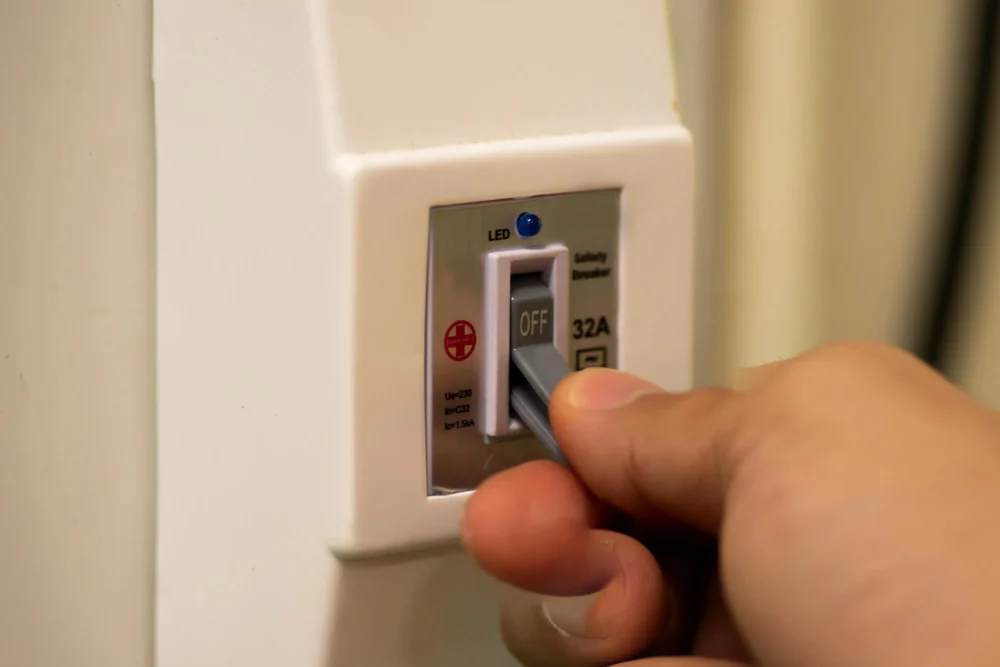 AC breaker being checked during HVAC services Coral Springs