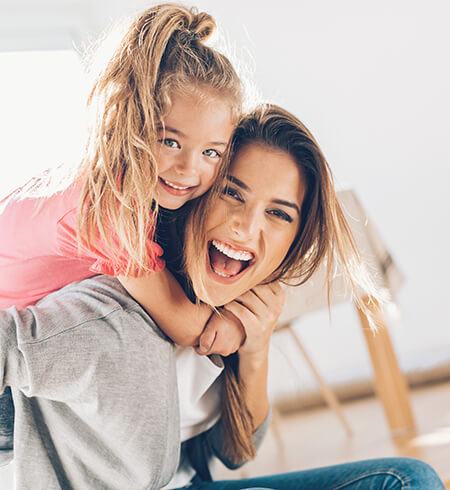 mom giving daughter piggy back ride indoor air quality