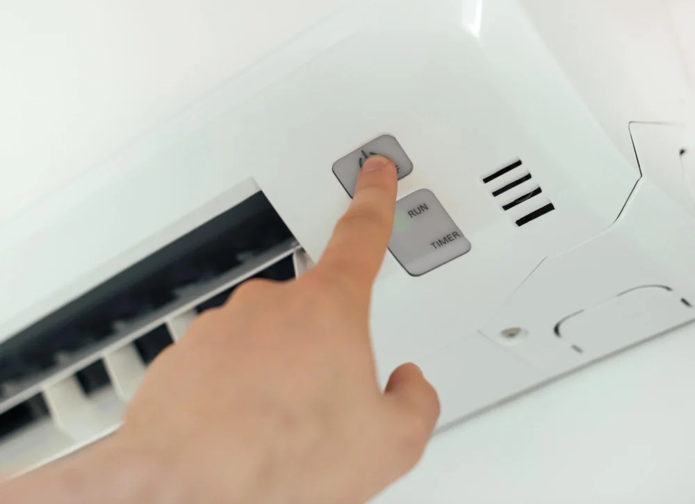 person turning AC on after emergency AC repair Coral Springs